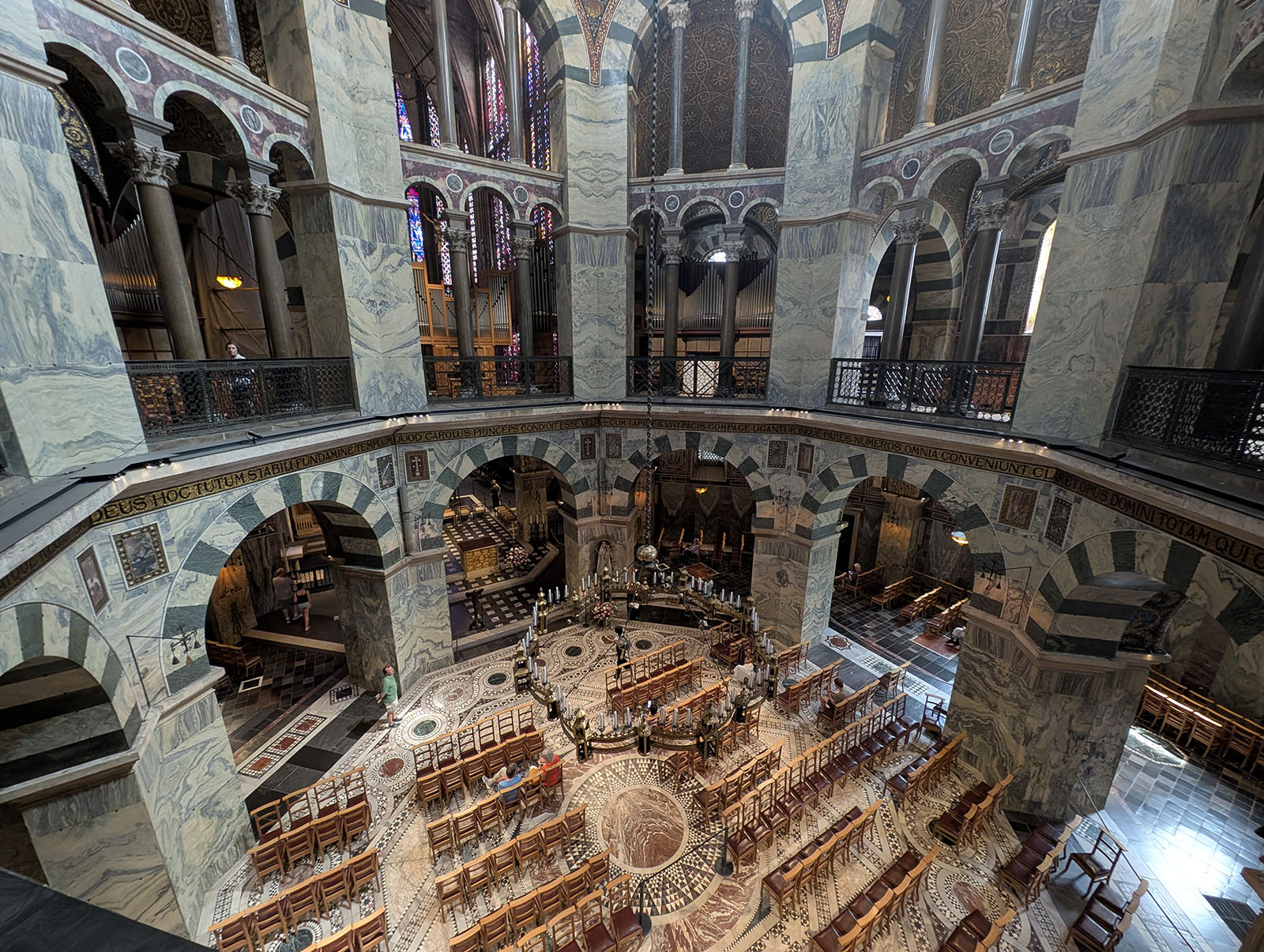 Interior, looking down at the octagon. A two-level space with marble walls and an intricate mosaic floor, seats for worshippers.